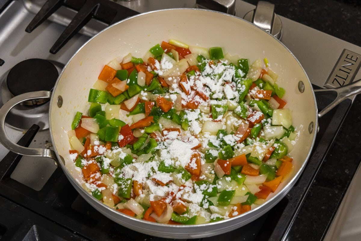 cornstarch sprinkled over chopped vegetables in a skillet
