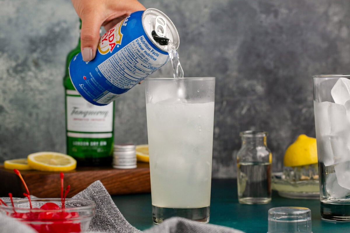 pouring club soda over tom collins