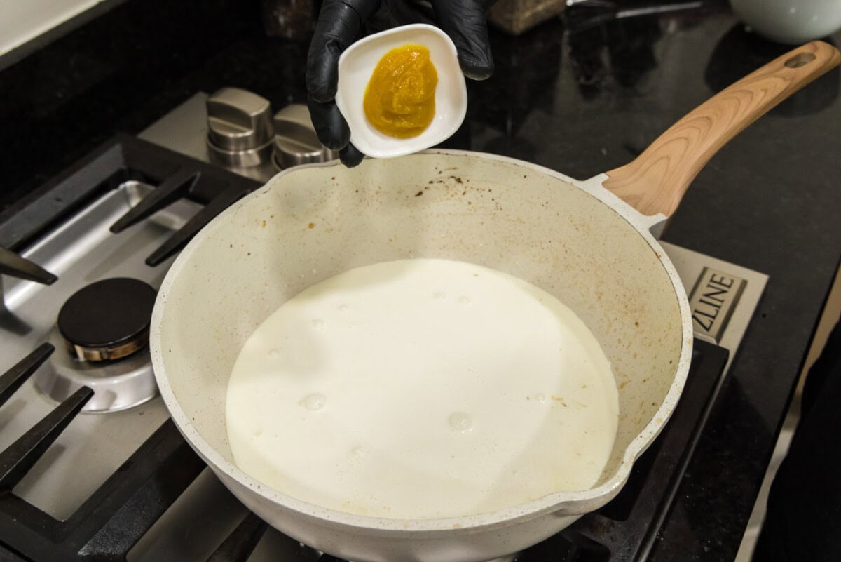 adding chicken base to heavy cream in skilet