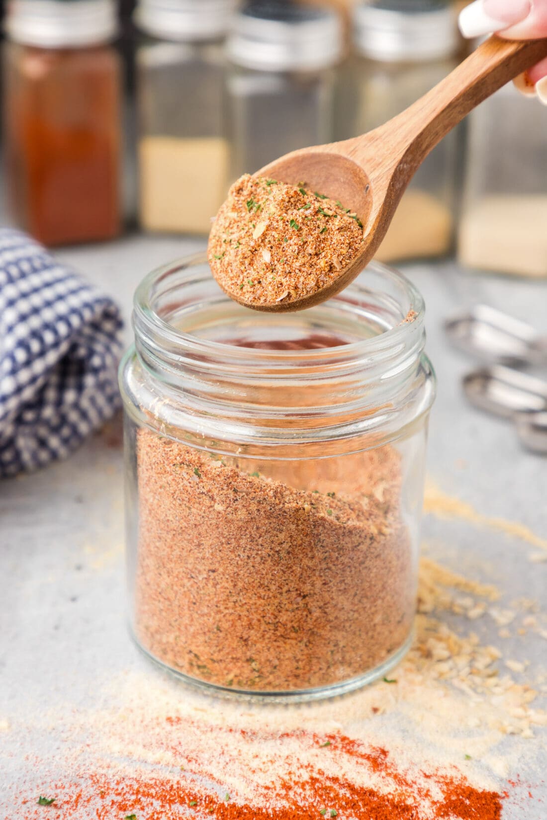 Spoonful of All Purpose Seasoning being lifted out of a jar of All Purpose Seasoning