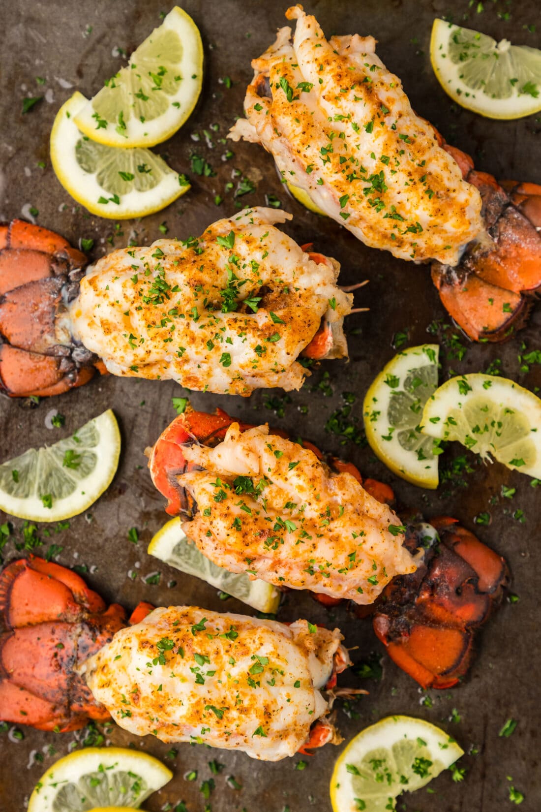 Baked Lobster Tails on a baking sheet with lemons