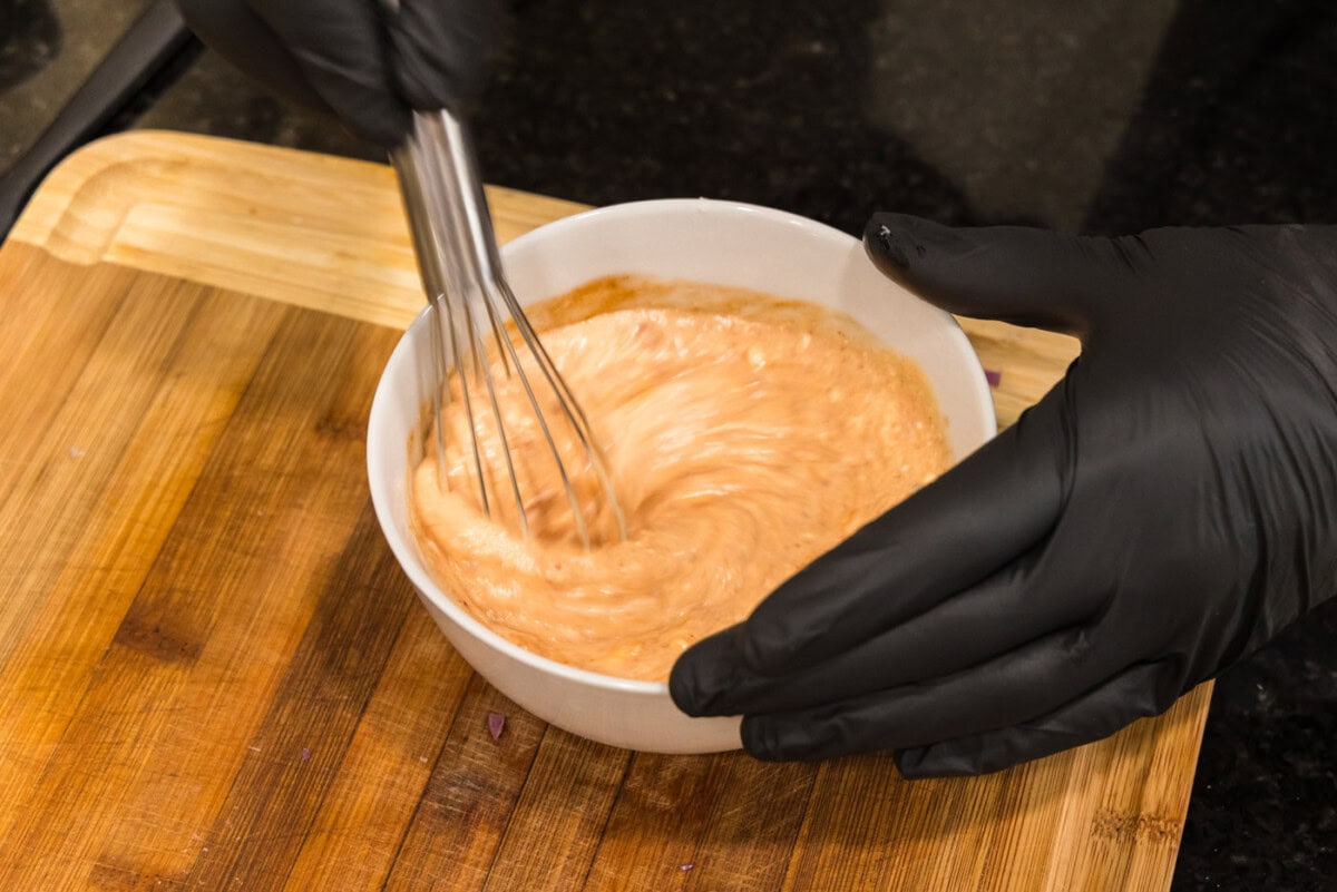whisking bang bang sauce in a bowl