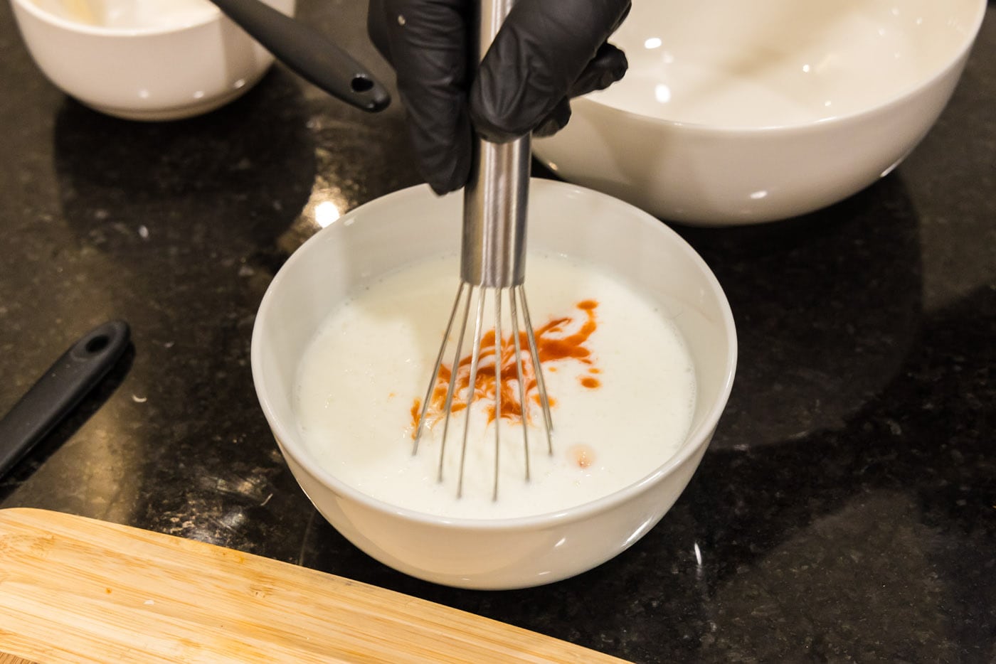 whisking hot sauce and buttermilk in a bowl