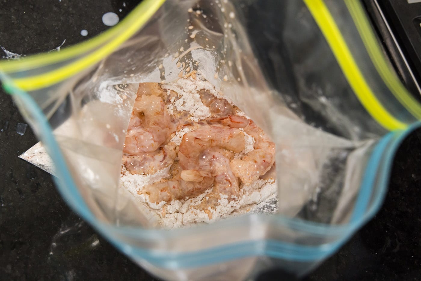 marinated shrimp added to flour in a large bag
