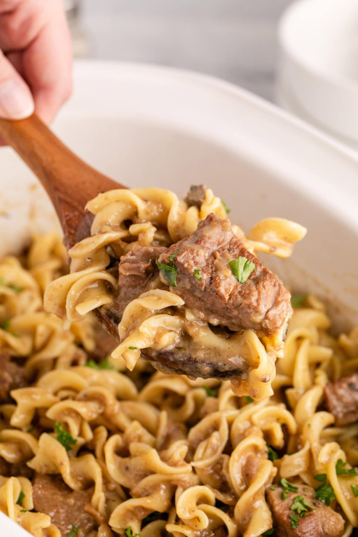 Spoonful of Beef and Noodles being lifted out of a crockpot