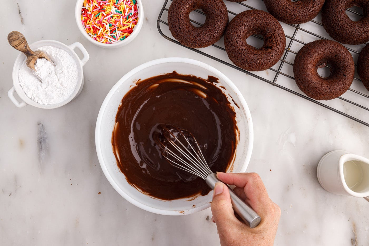 whisking chocolate glaze in a bowl
