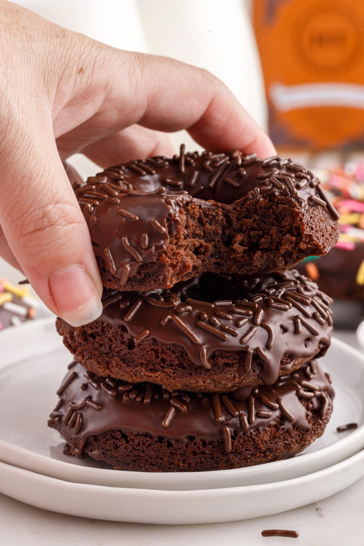 Hand placing a Bronut on a stack of Bronuts