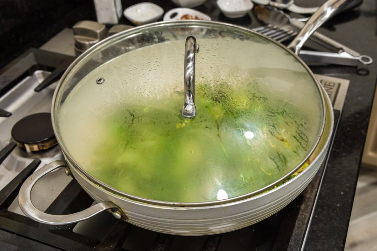 lid over the top of brussels sprouts in a skillet