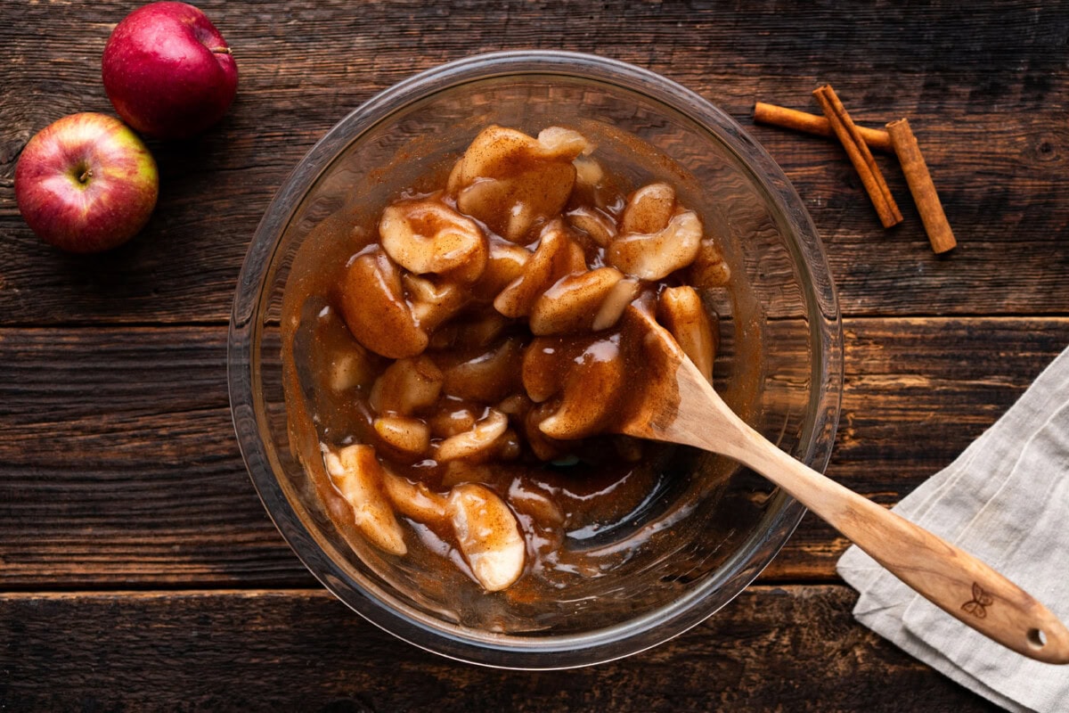 apple pie filling in a bowl with a wooden spoon