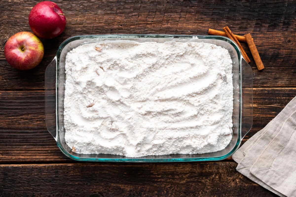 dry cake mix on top of apple pie filling in a baking dish