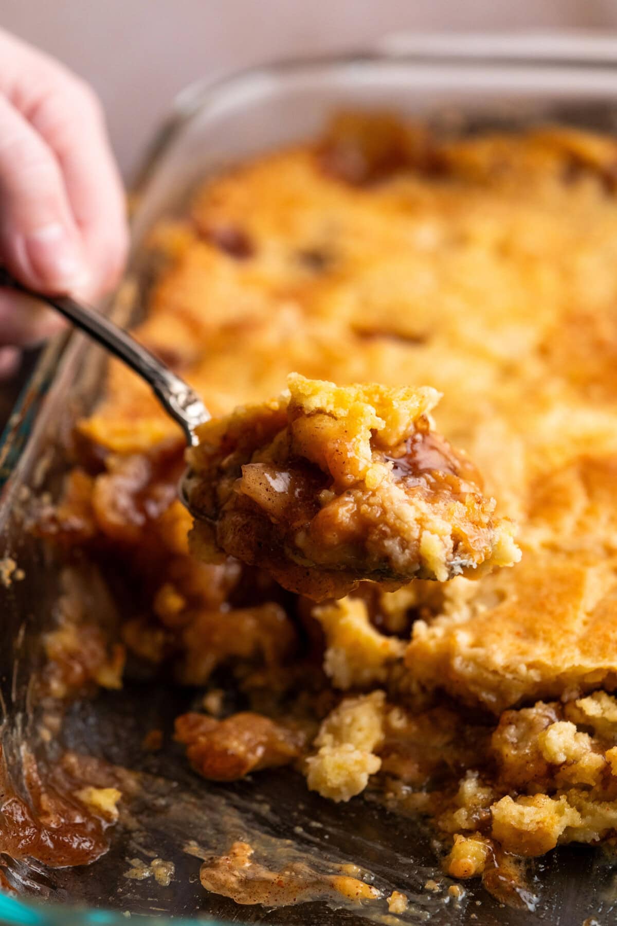 Scoop of Caramel Apple Dump Cake being lifted out of the pan