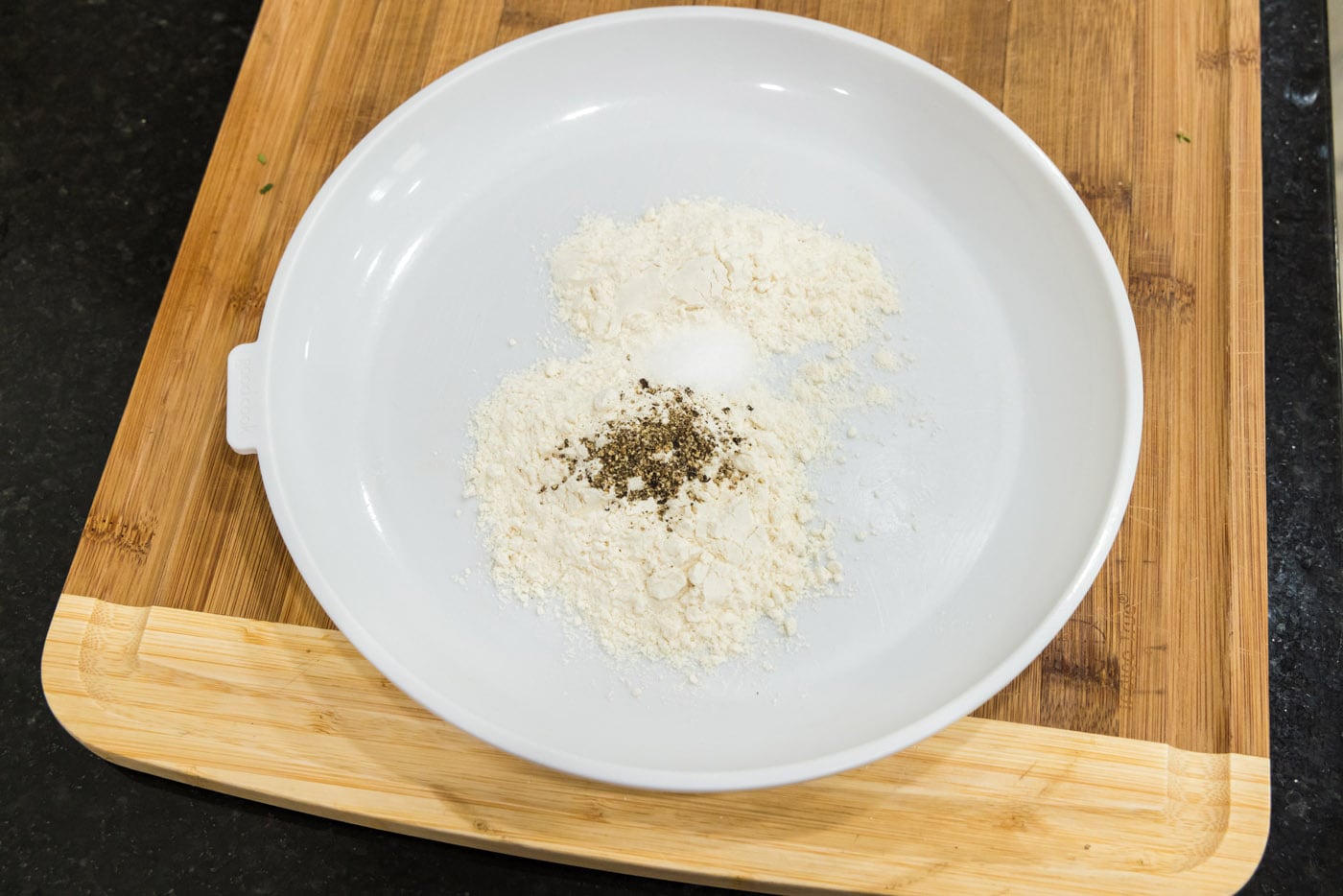 flour with salt and pepper on a plate