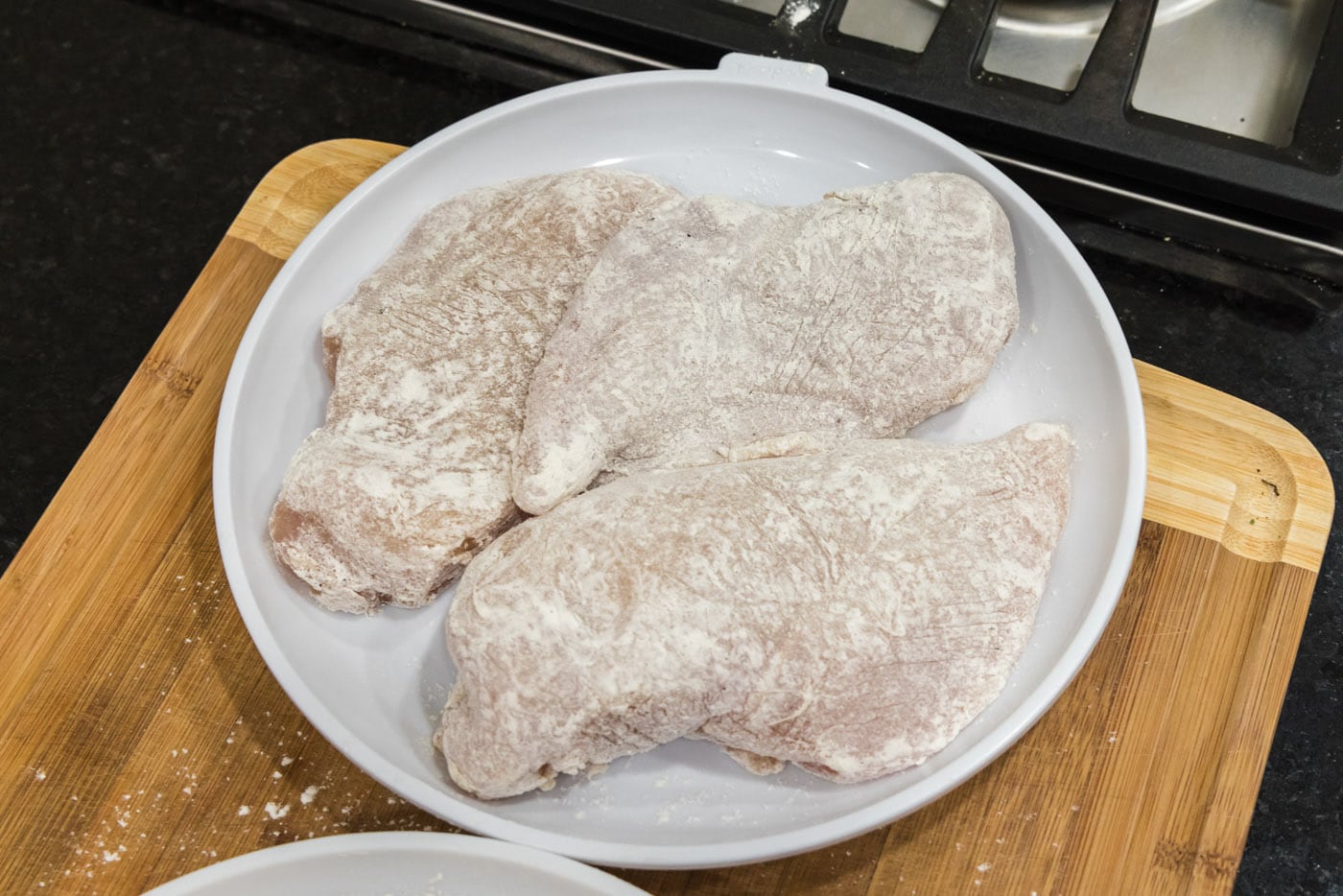 flour coated chicken breasts on a plate