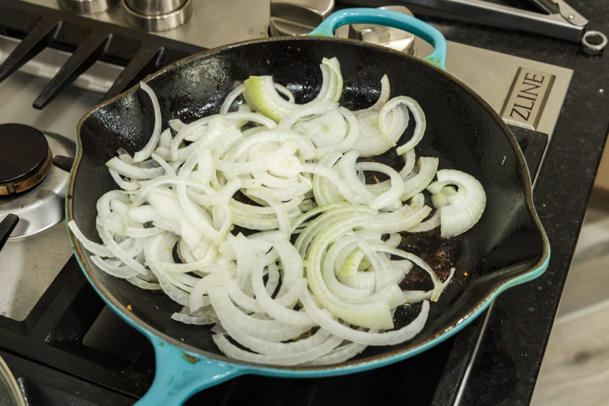 raw sliced onion in a skillet