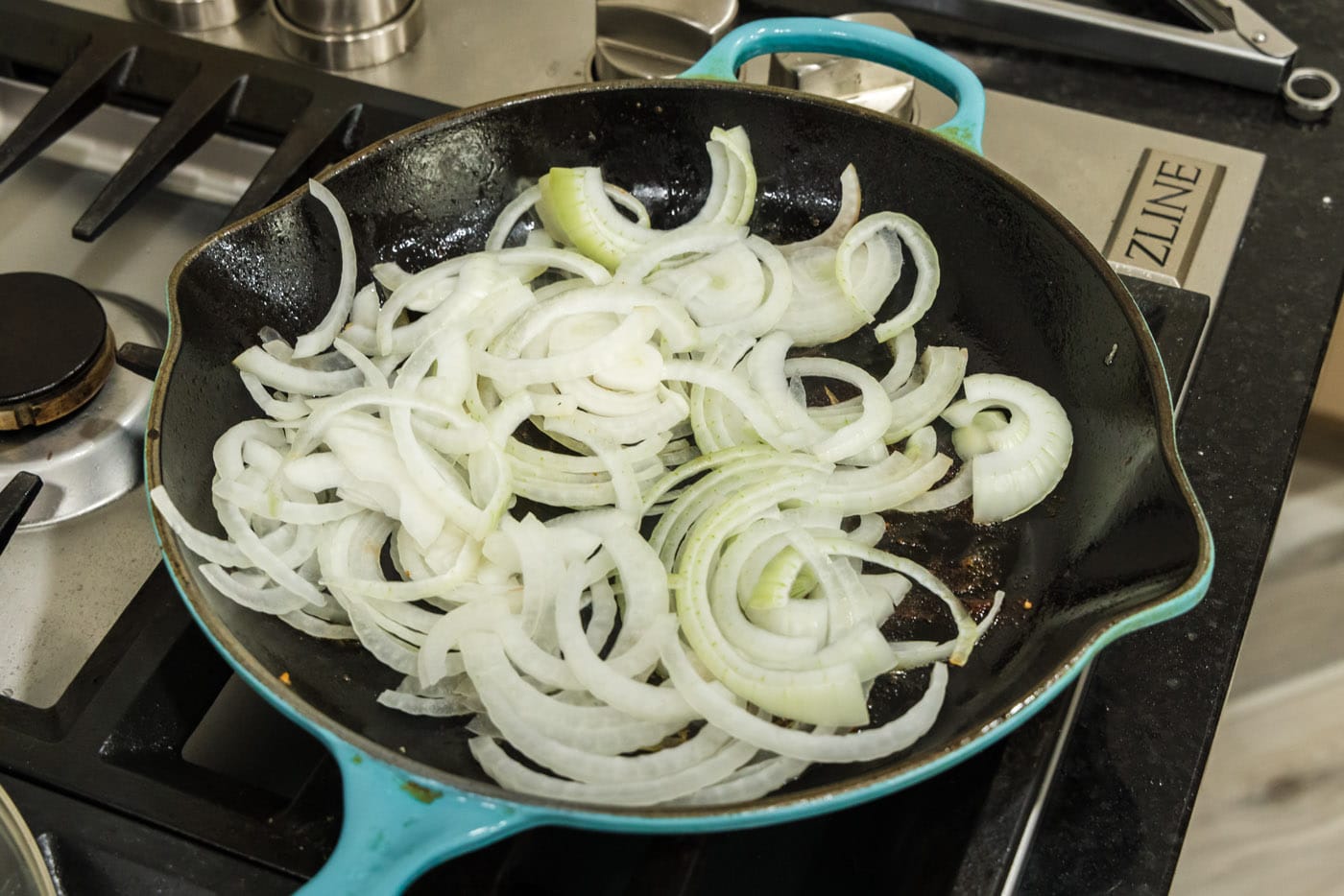 raw sliced onion in a skillet