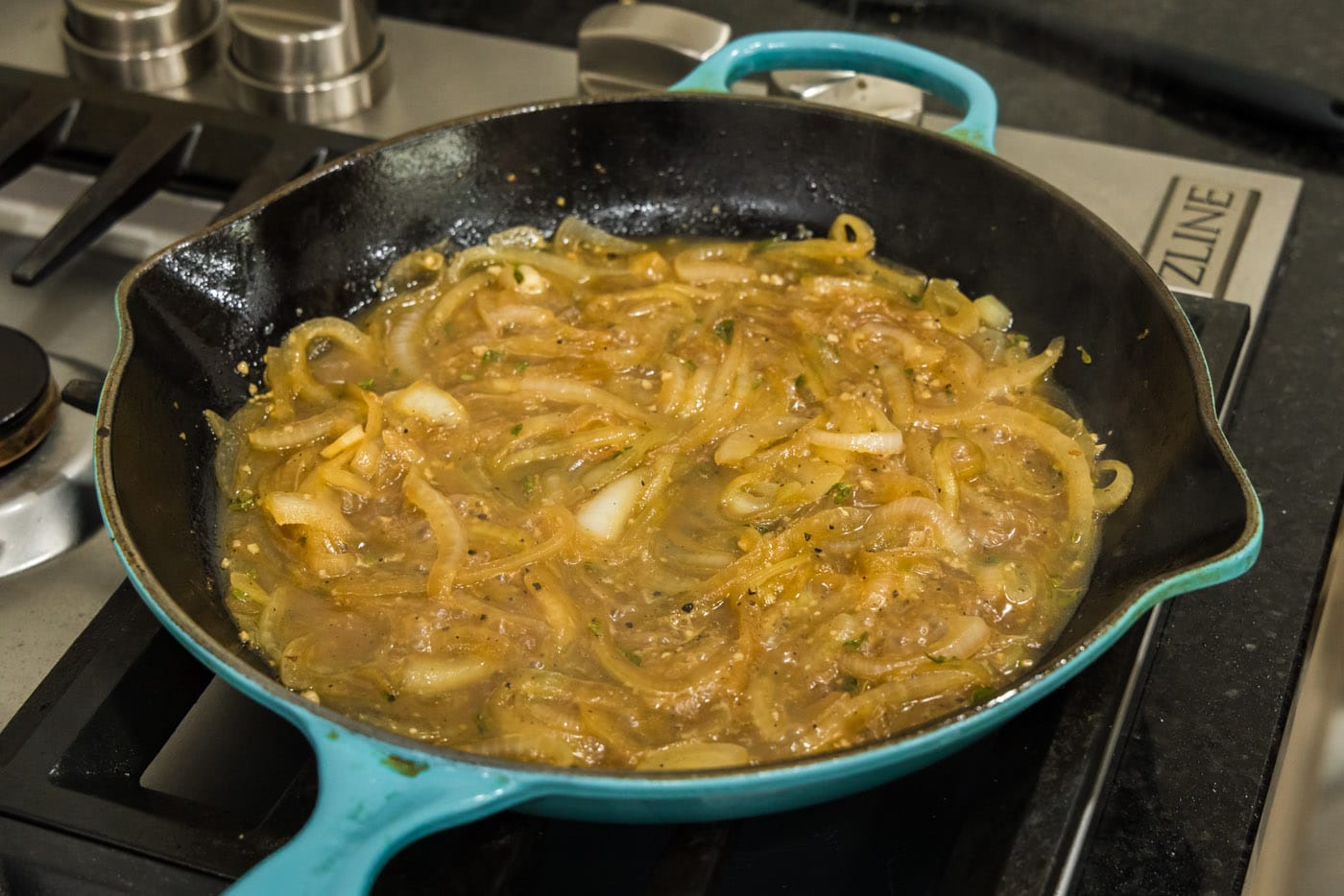bubbling onion thyme sauce in a skillet