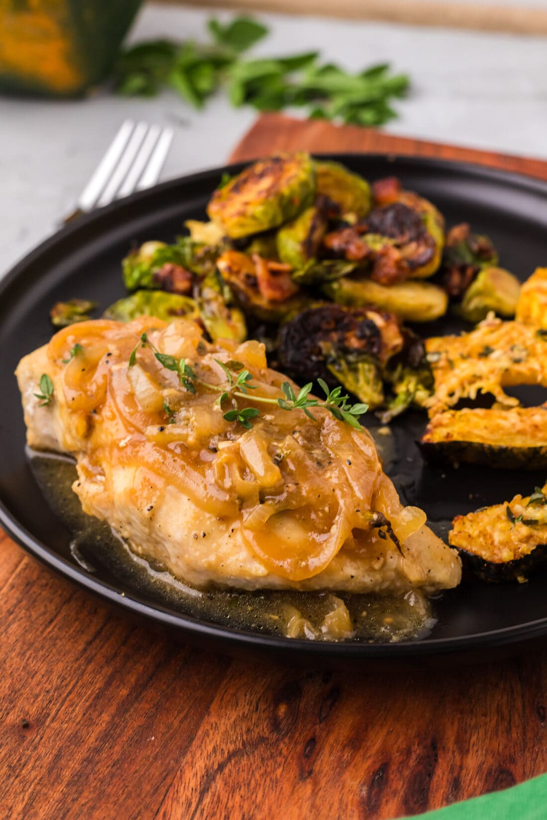 Chicken with Onion Thyme Sauce on a plate with Brussels sprouts and acorn squash