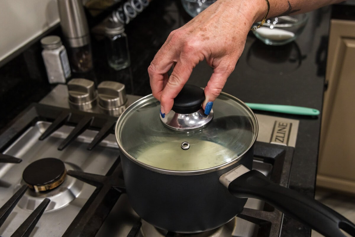 placing lid on saucepan