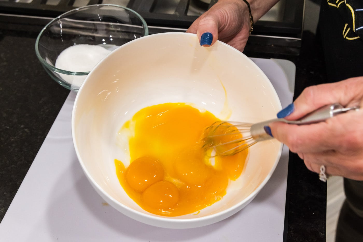 whisking egg yolks in a bowl