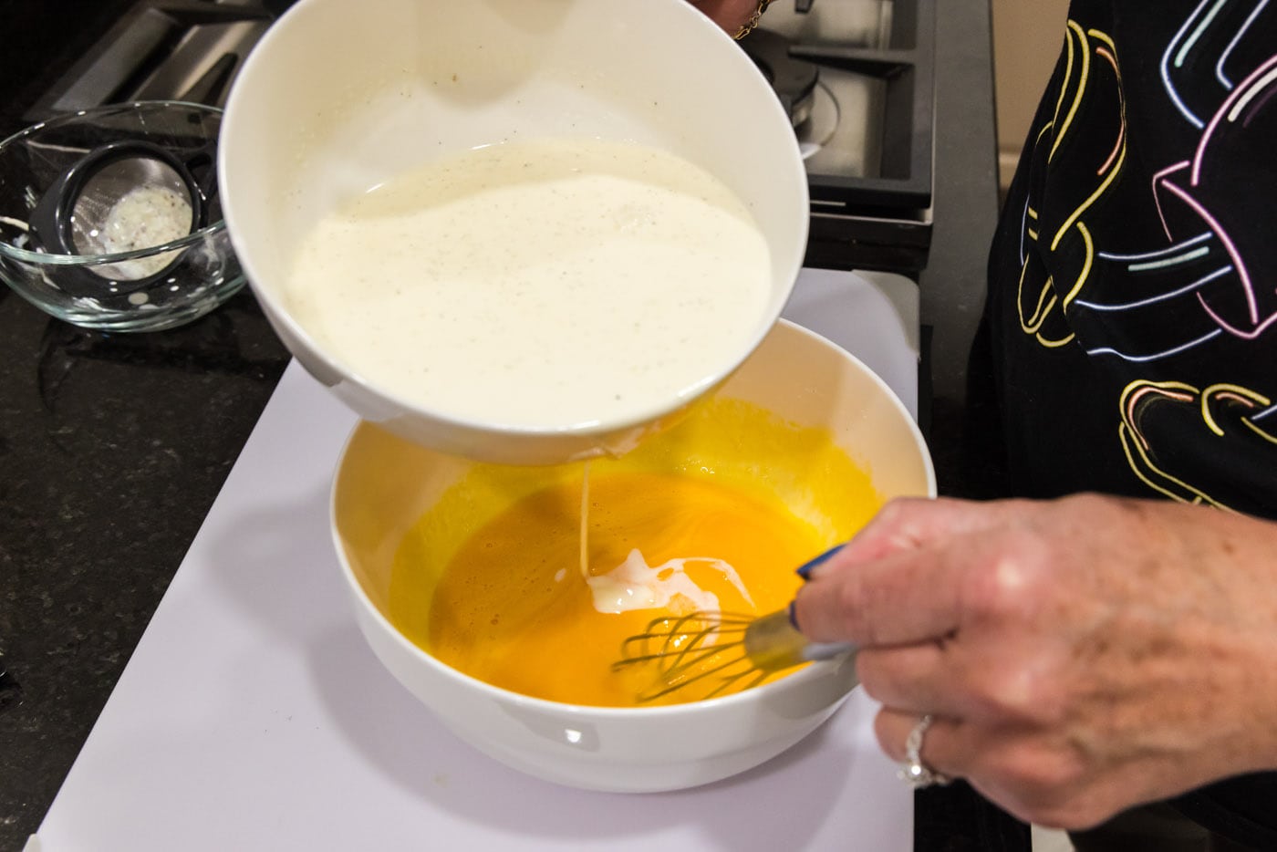 slowly whisking heavy cream mixture into egg yolks