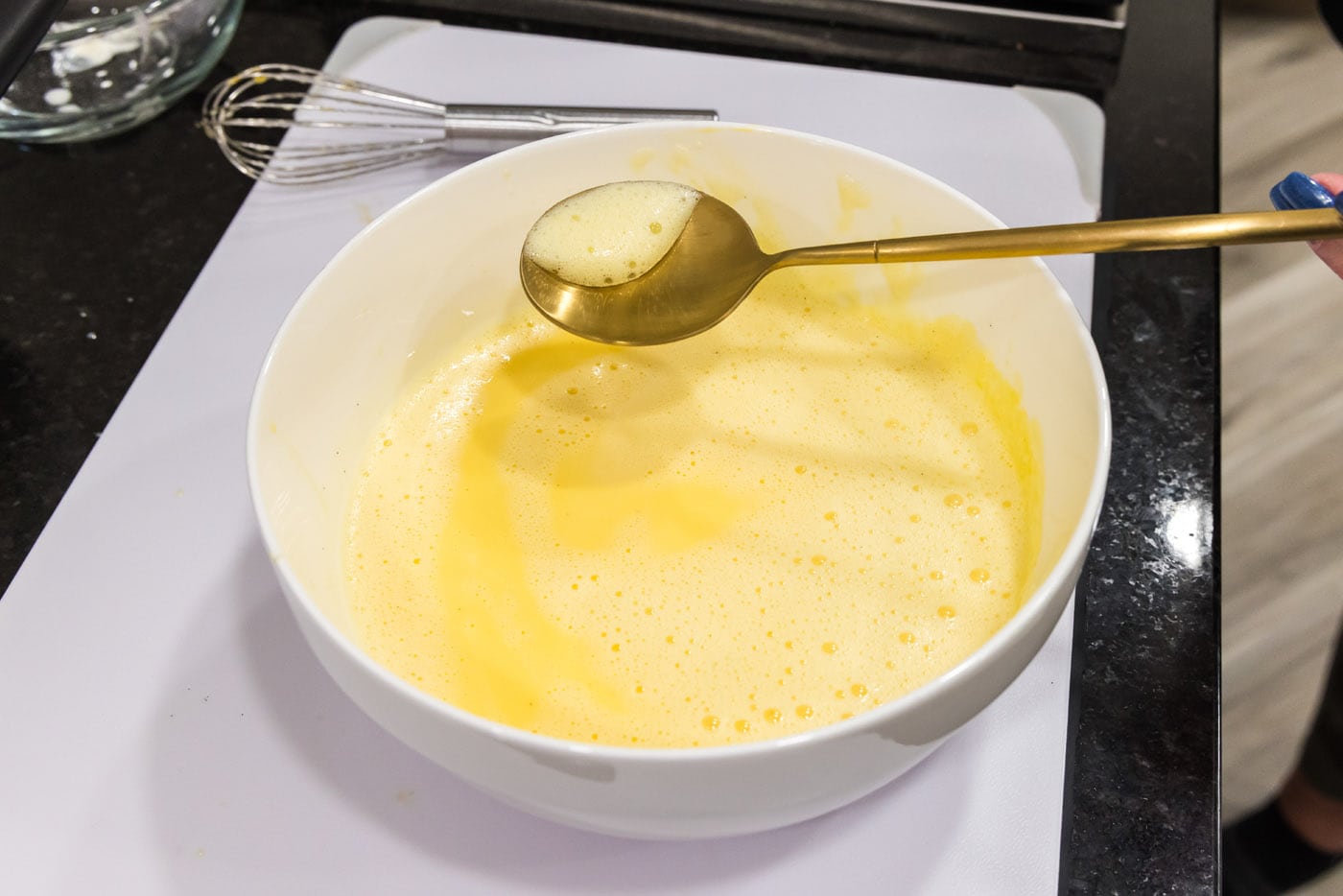 scooping froth from egg mixture