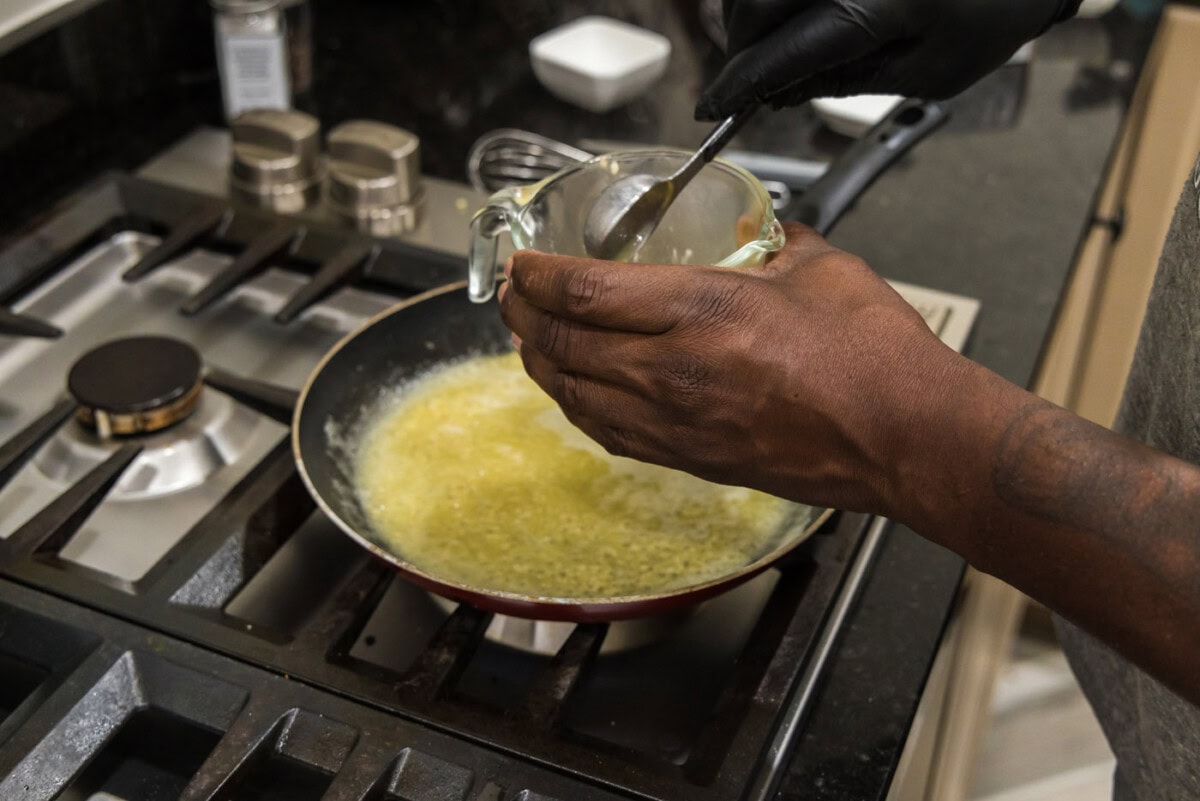 adding cornstarch slurry to skillet of garlic butter