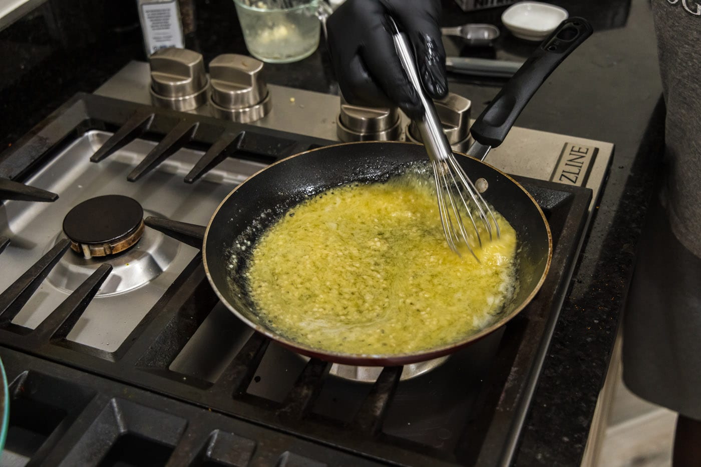 whisking garlic butter sauce in a skillet
