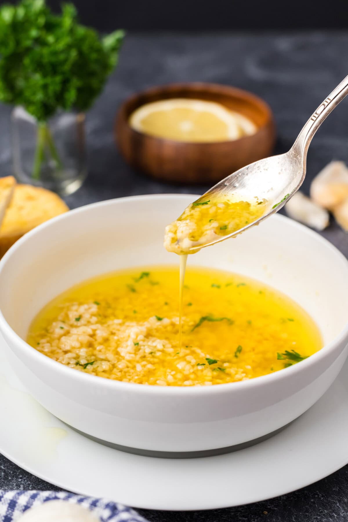 Spoon drizzling Garlic Butter Sauce into a bowl of Garlic Butter Sauce