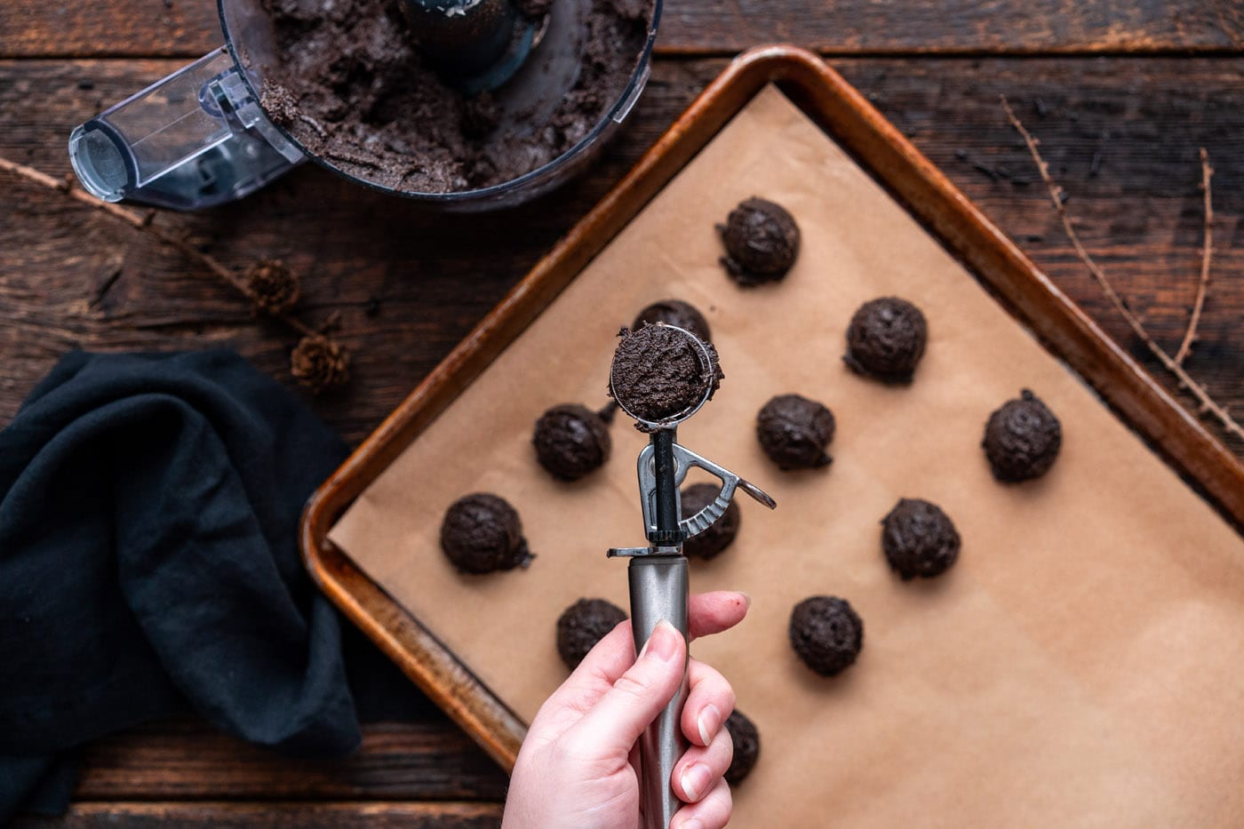 scoop of oreo truffles over a baking sheet