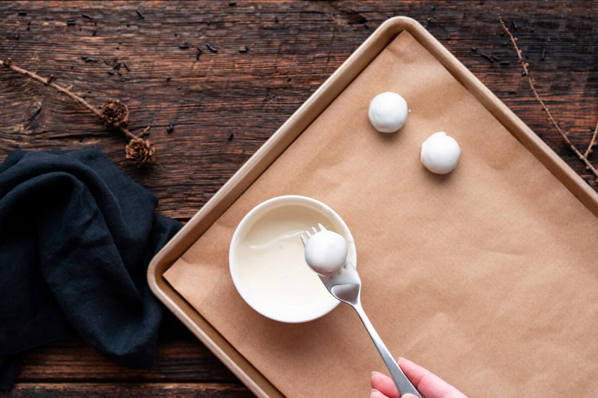 dipping oreo truffle into white chocolate