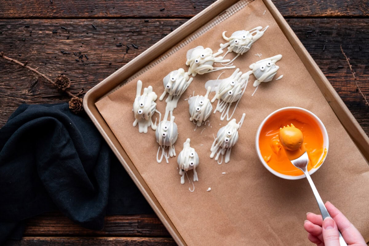 dipping oreo truffle into orange candy melts