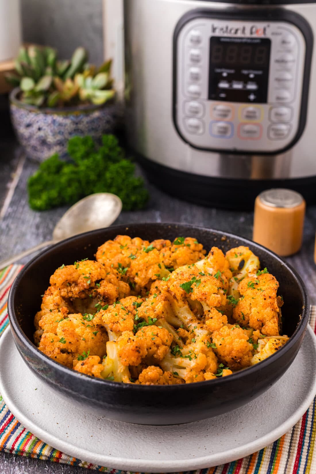Bowl of Instant Pot Cauliflower with an Instant Pot in the background