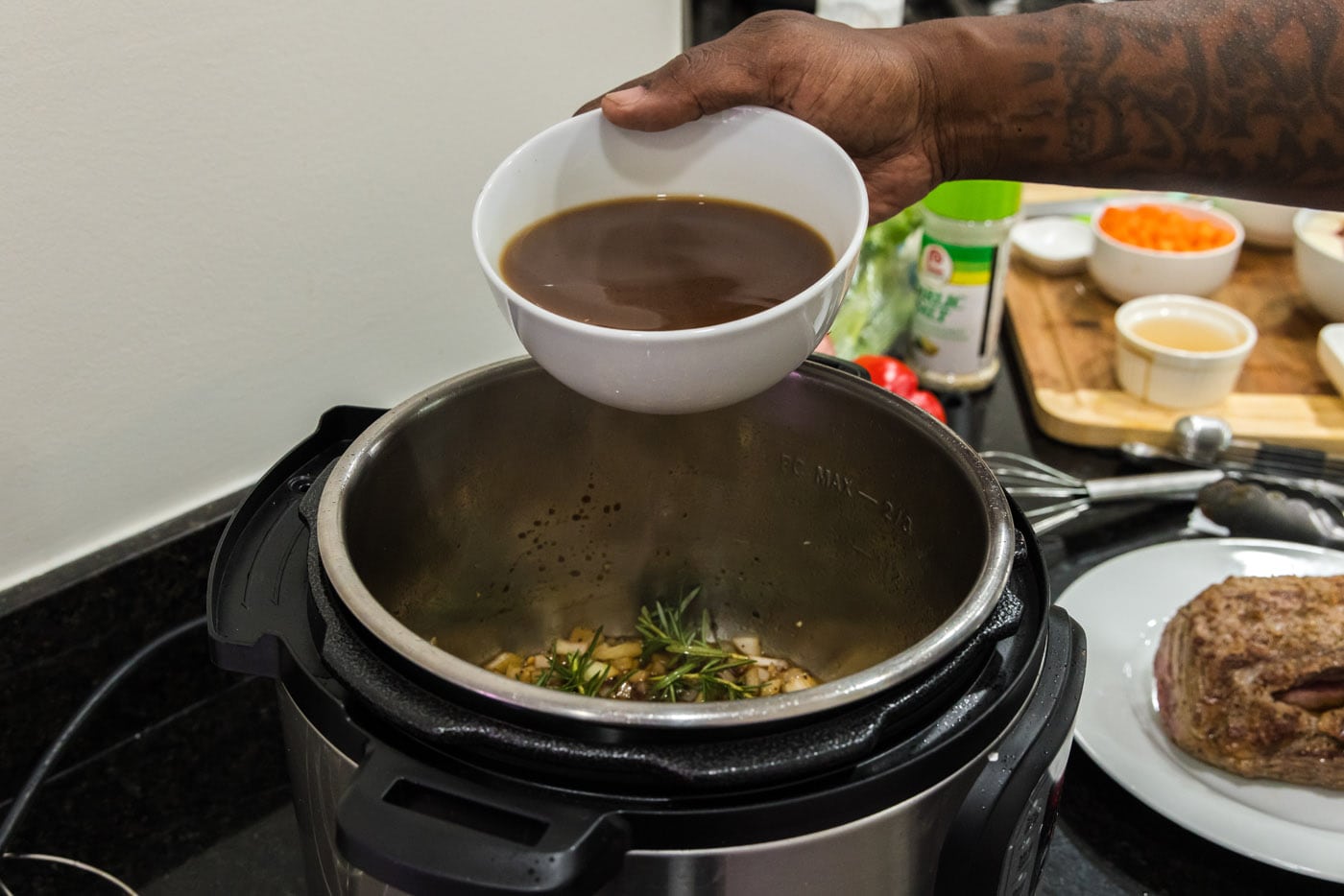 pouring beef broth into instant pot with onion mixture