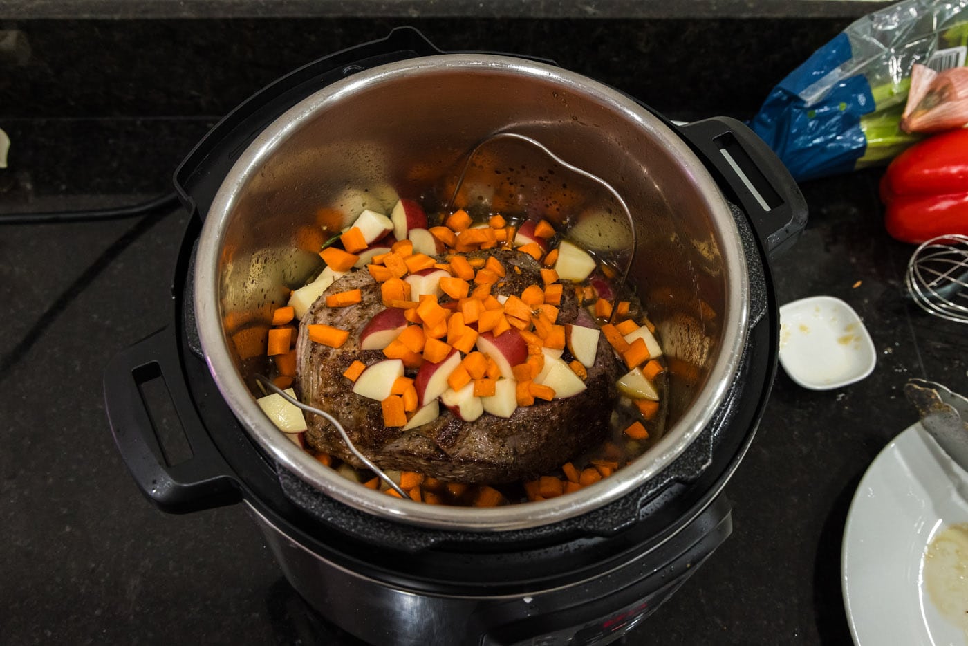carrots and potatoes added to instant pot with roast beef