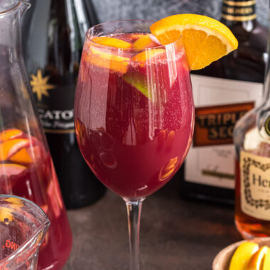 Close up photo of a glass of Mexican Inspired Sangria garnished with an orange wedge