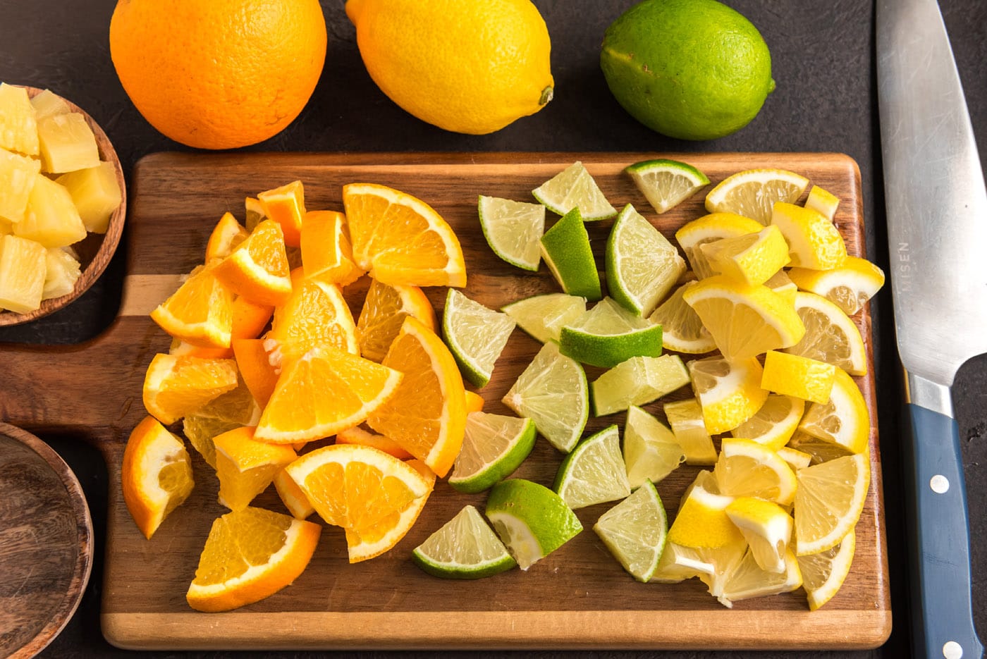 sliced oranges, limes, and lemons on a cutting board