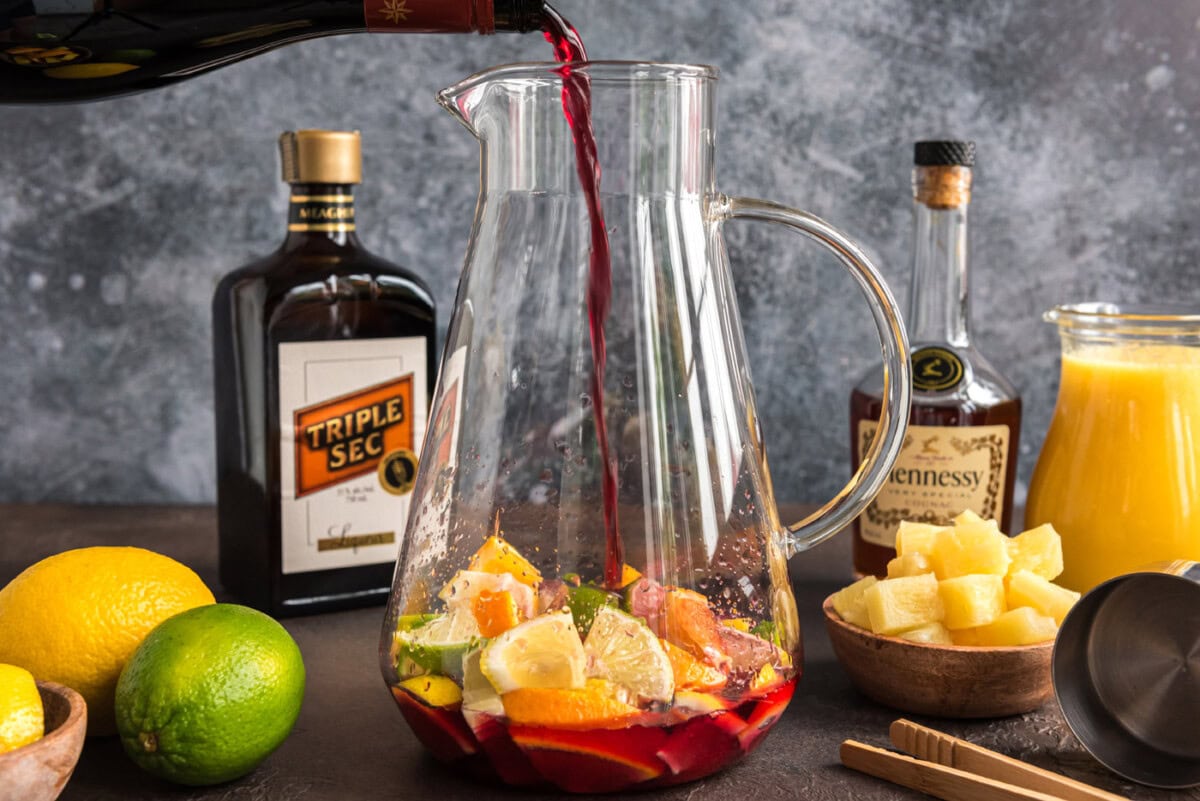 pouring red moscato into pitcher with fruit