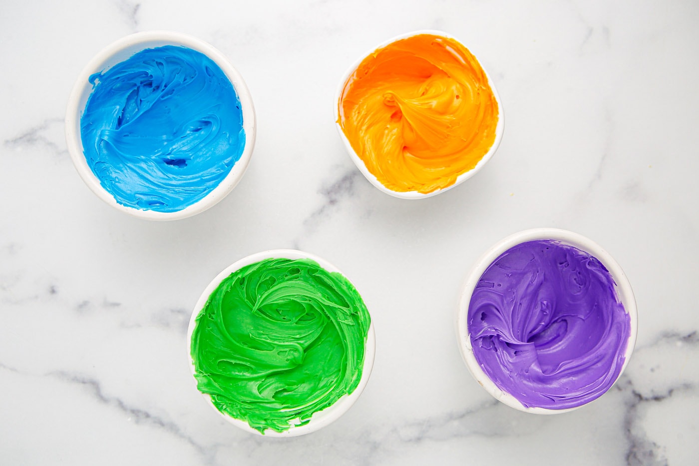 halloween colored frosting in bowls