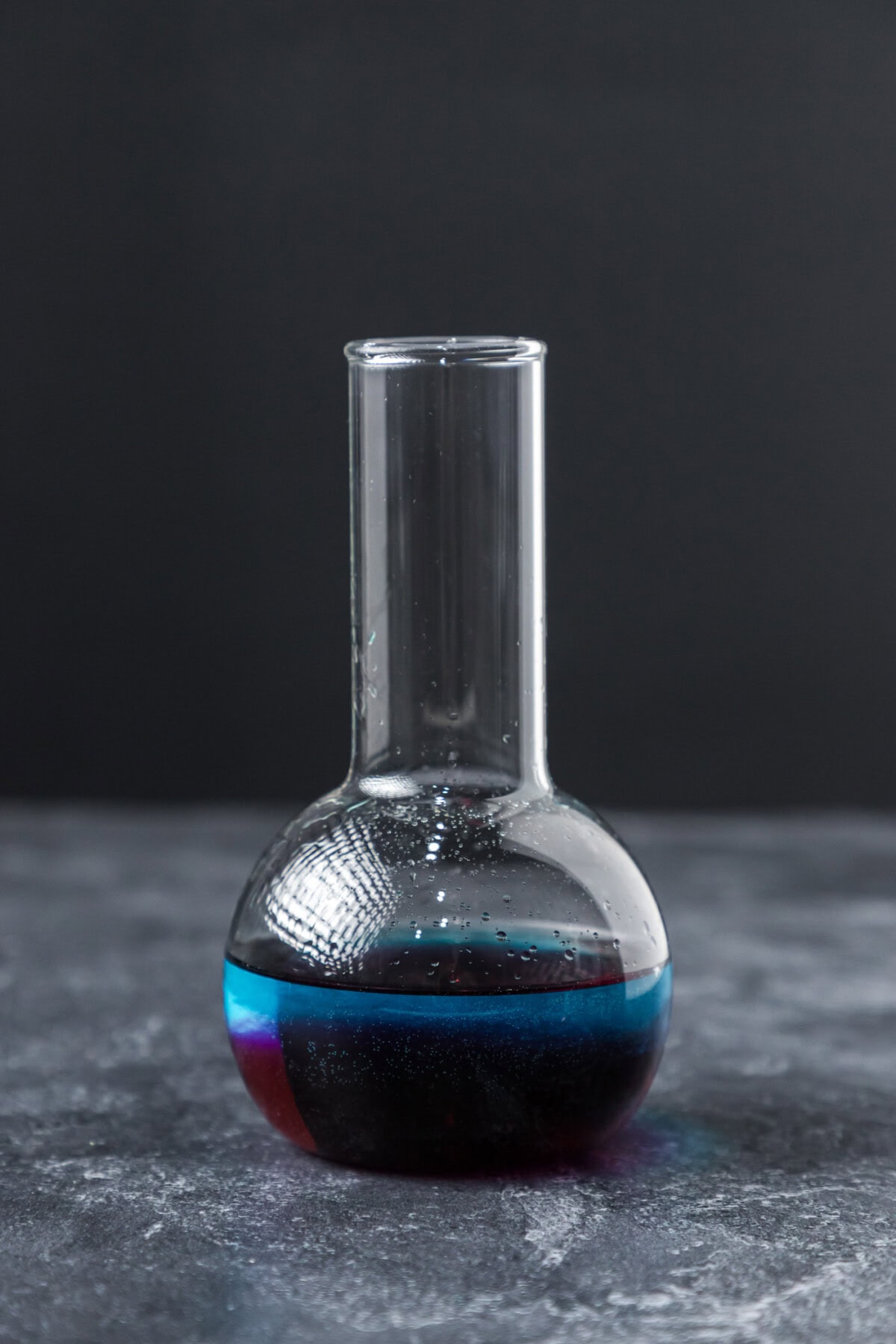 purple people eater cocktail in a beaker glass