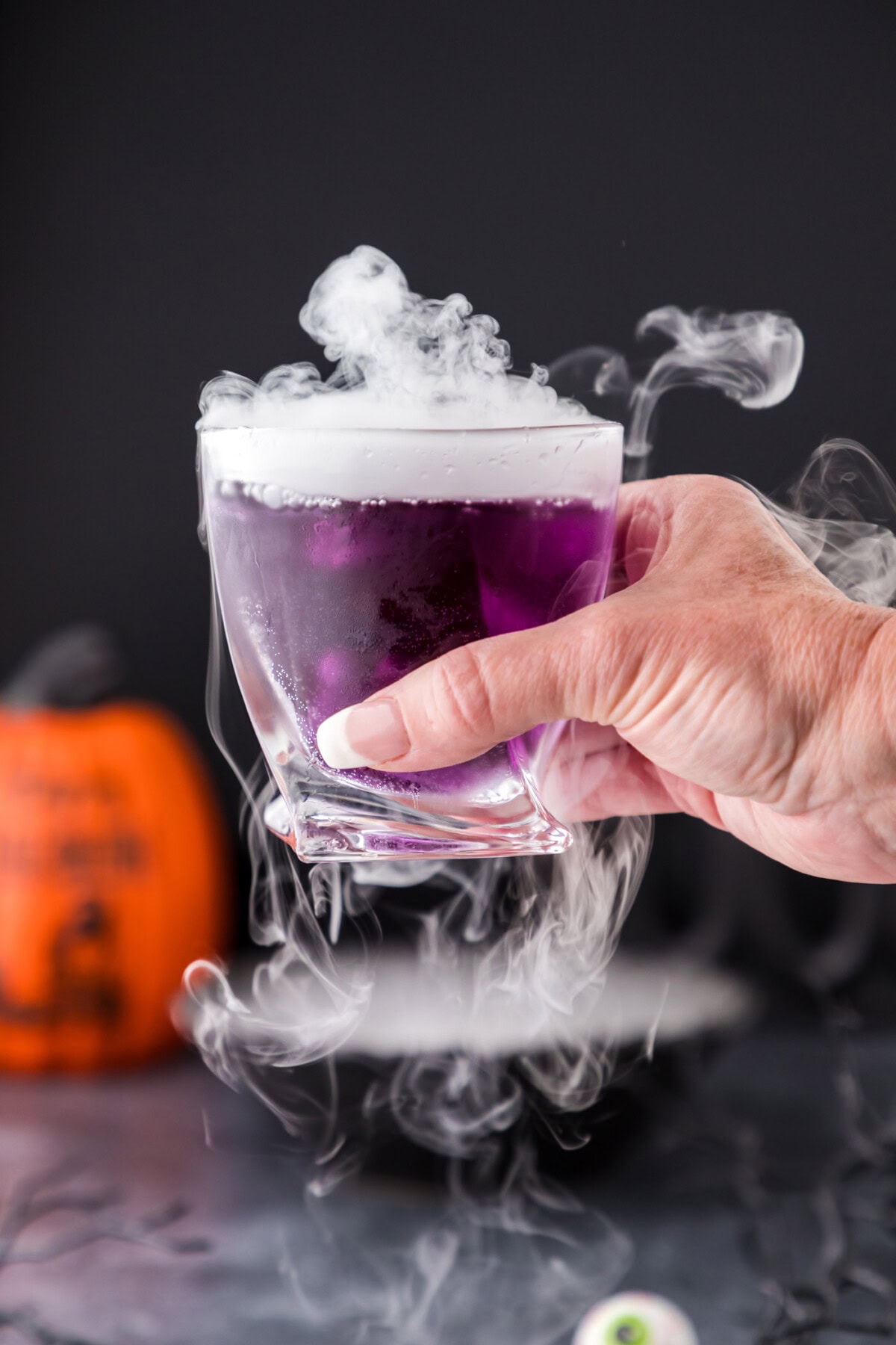 Hand holding up a Purple People Eater Cocktail