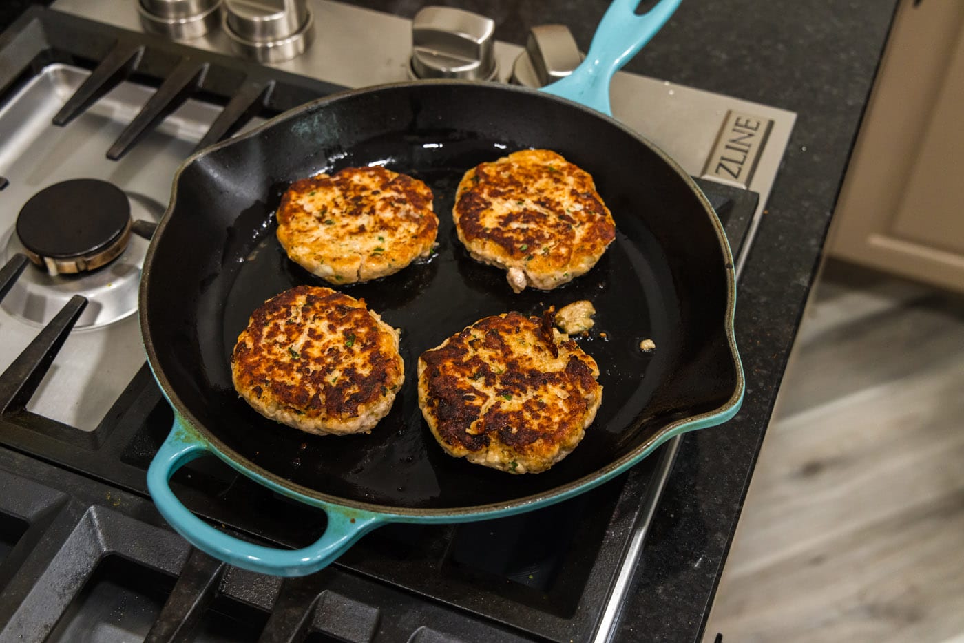 salmon burgers cooked on a skillet
