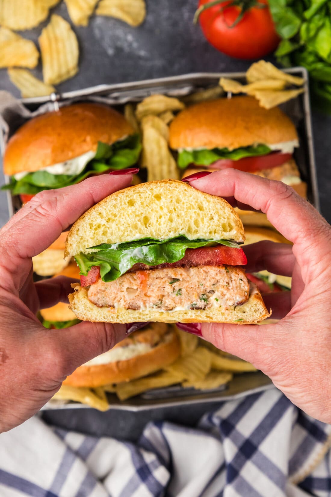 Hands holding up a half of a Salmon Burger