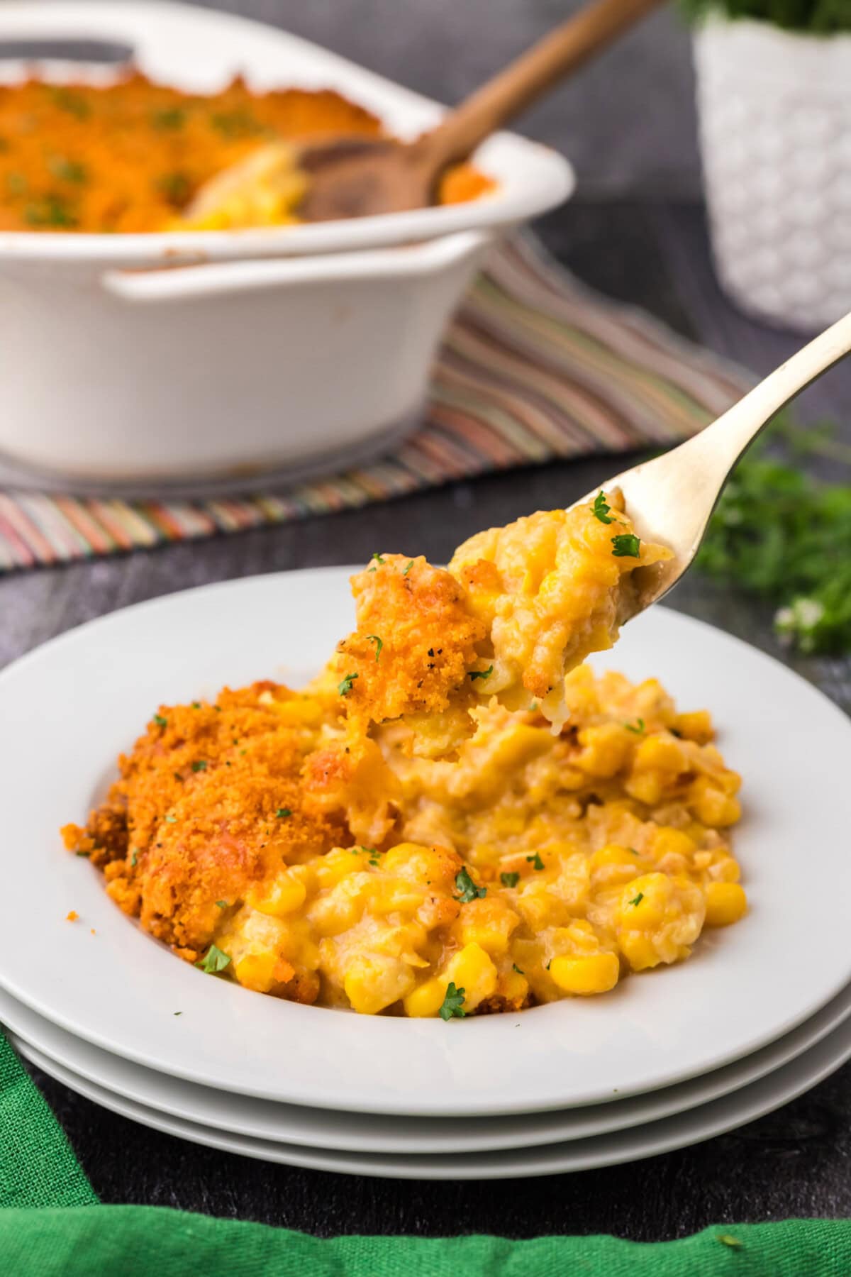 Forkful of Scalloped Corn being lifted off a plate 