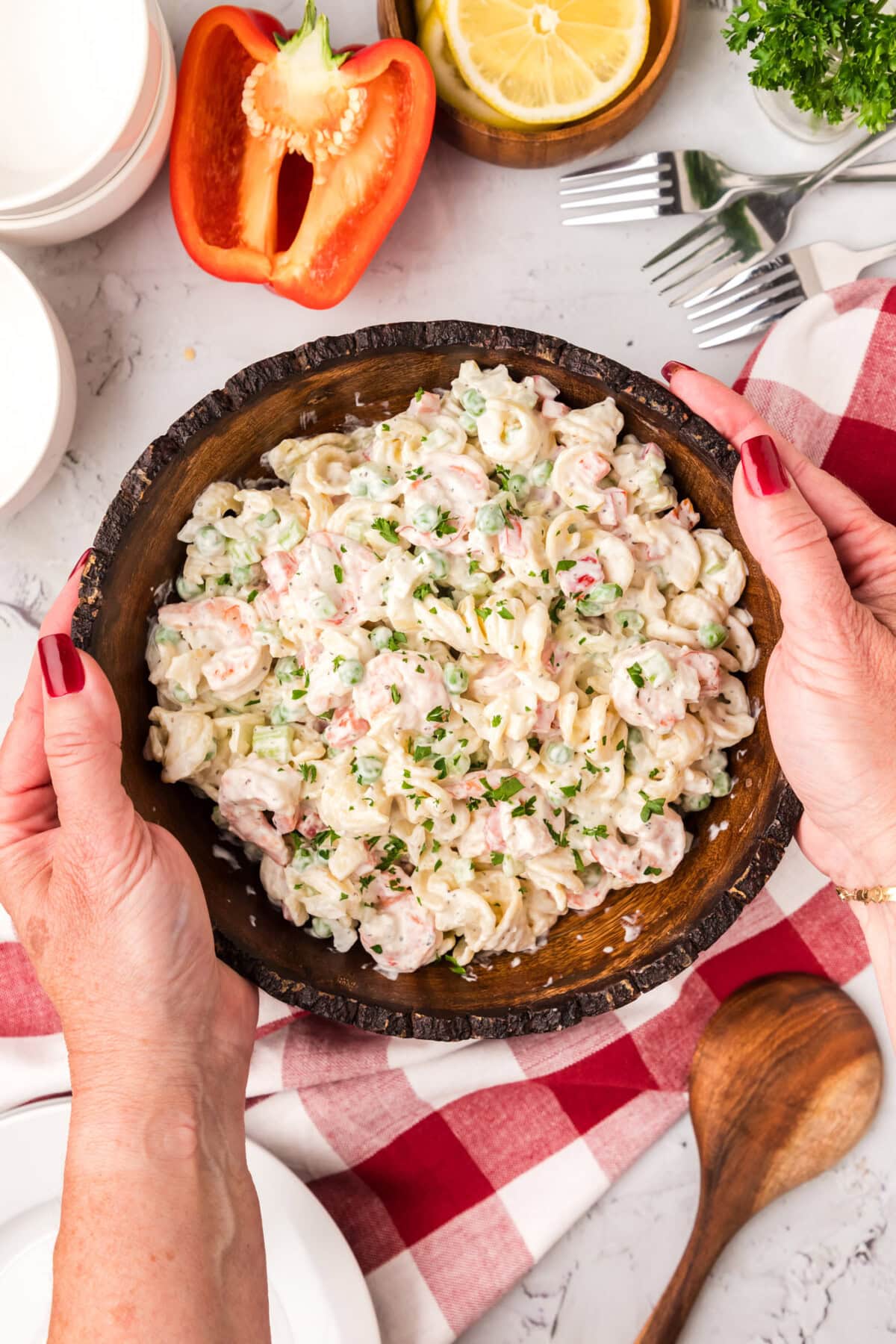 Hands holding a bowl of Shrimp Pasta Salad