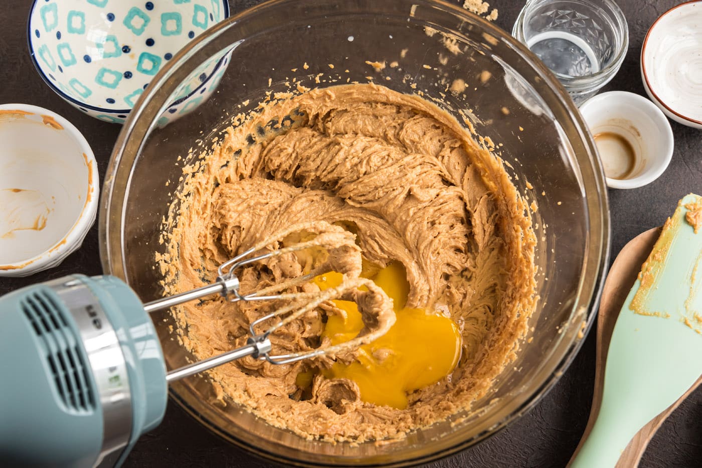 adding egg to peanut butter cookie dough with a mixer