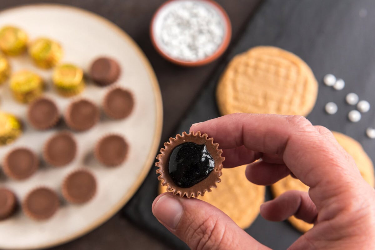 black decorator gel on the bottom of a reeses peanut butter cup