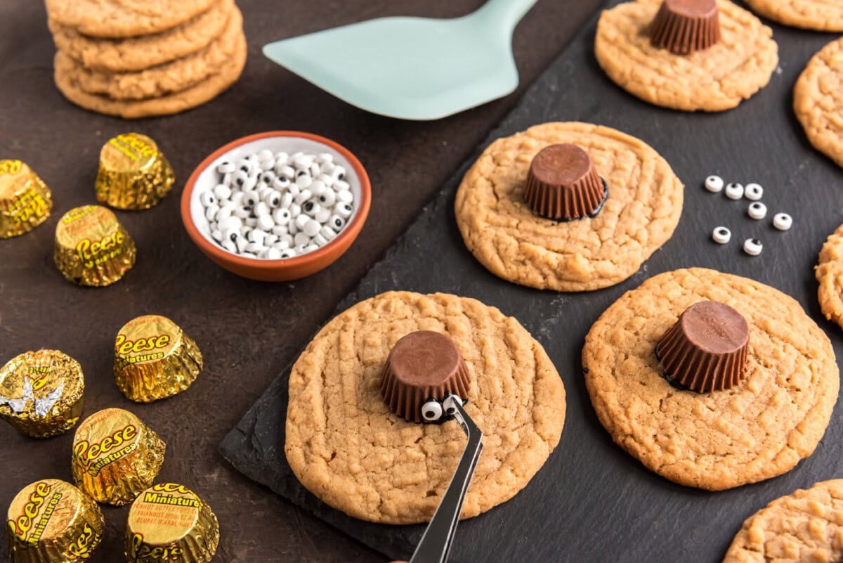sticking candy eyeballs to peanut butter cup