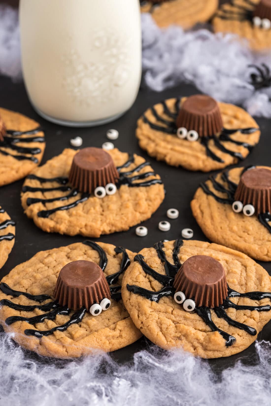 Spider Cookies on a platter with a jar of milk in the background