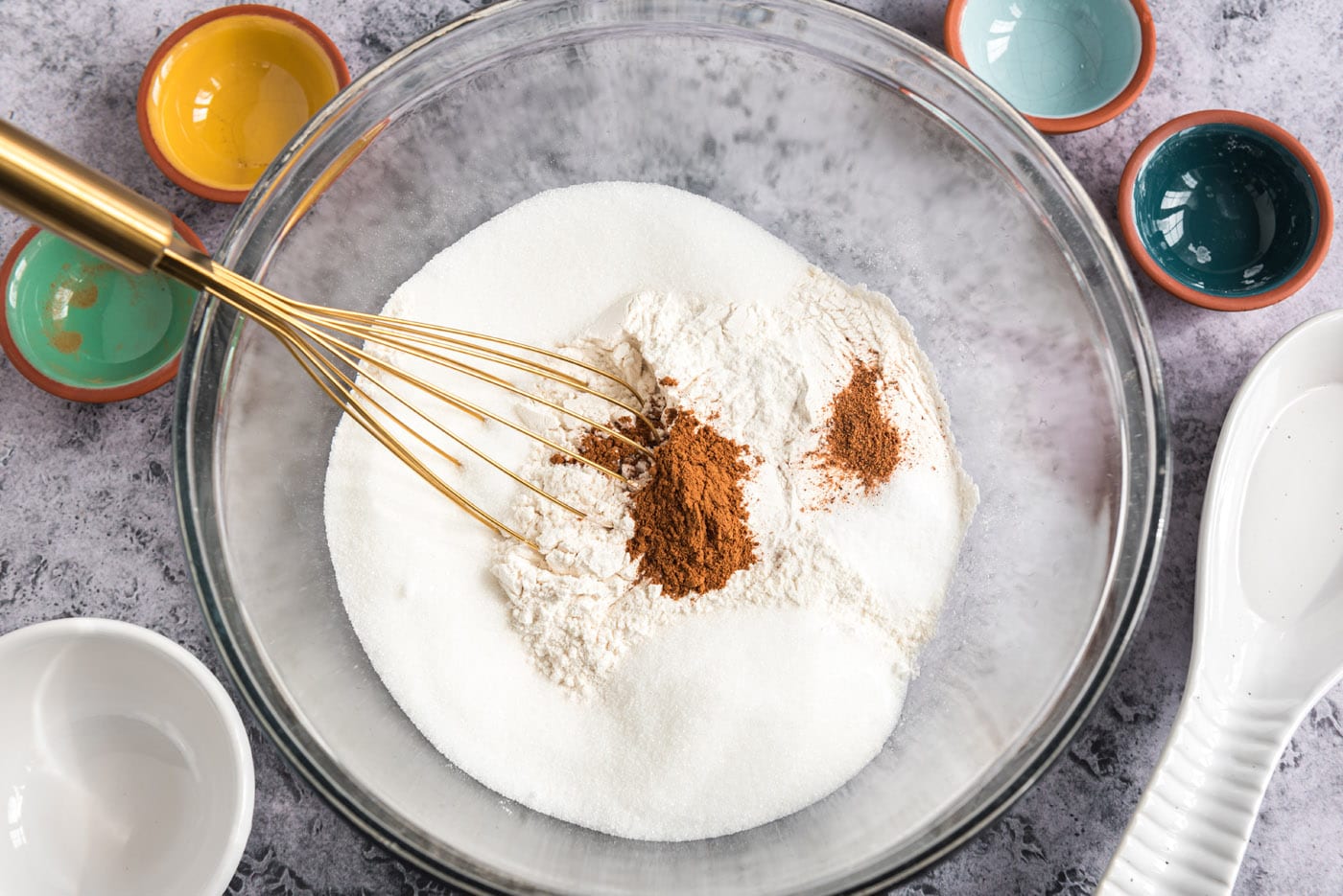 sugar, cinnamon, flour, nutmeg, and baking powder in a bowl with a whisk