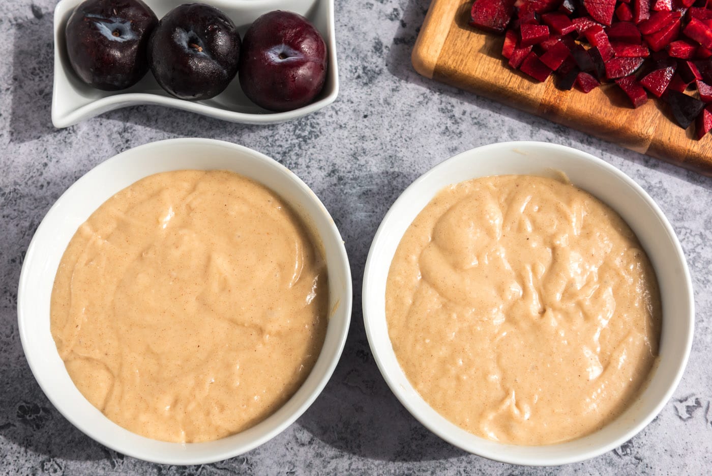 plum muffin batter divided into two bowls